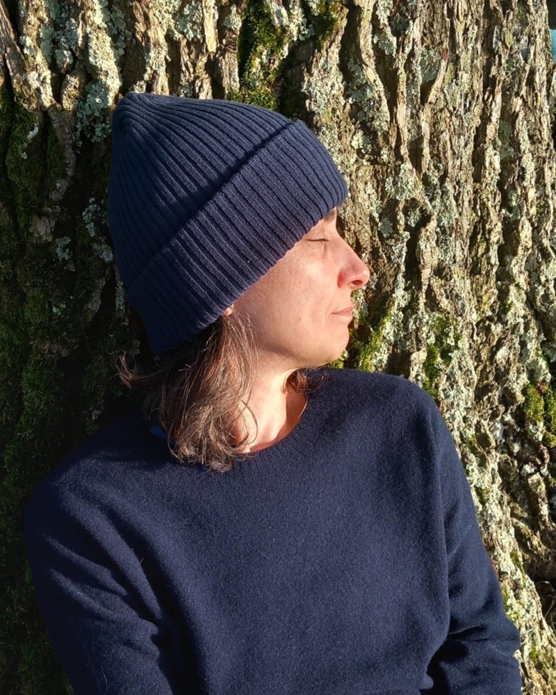Alice Doherty, eyes closed, resting against an old tree in the sun